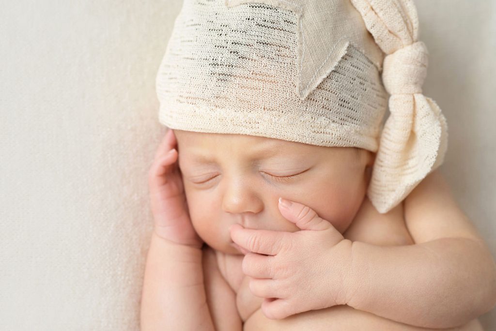 babyportrait mit zipfelmütze, darauf ist ein großer stern